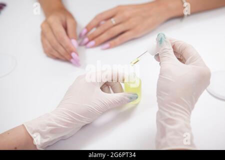 Nahaufnahme eines Manikuristen mit Nagelhautöl Stockfoto