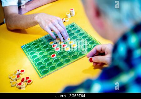 Wardenburg, Deutschland. Juli 2021. Ein Spieler legt während einer Spielrunde „Reversi“ zweifarbige Spielsteine auf das Brett. Reversi ist ein strategisches Brettspiel für zwei Personen. Quelle: Hauke-Christian Dittrich/dpa/Alamy Live News Stockfoto