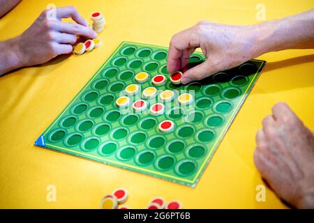 Wardenburg, Deutschland. Juli 2021. Ein Spieler legt während einer Spielrunde „Reversi“ zweifarbige Spielsteine auf das Brett. Reversi ist ein strategisches Brettspiel für zwei Personen. Quelle: Hauke-Christian Dittrich/dpa/Alamy Live News Stockfoto