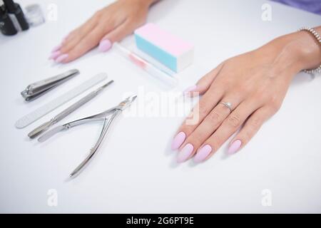 Schöne weibliche Hände mit rosa Maniküre auf Nagel Salon Tisch Stockfoto