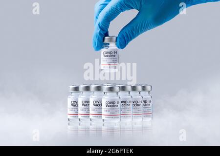 Gefrorene kalte Impfstofffläschchen für Covid-19-Impfstoff in der Hand im Labor. Gruppe von Coronavirus-Impfstoffflaschen. Stockfoto