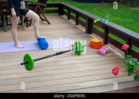 Frauen trainieren auf der Terrasse des Haushofs. Heimtrainingsgeräte. Fitness zu Hause. Gesund, Training und Lifestyle-Konzept. Stockfoto