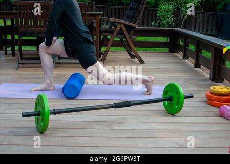 Frauen trainieren auf der Terrasse des Haushofs. Heimtrainingsgeräte. Fitness zu Hause. Gesund, Training und Lifestyle-Konzept. Stockfoto