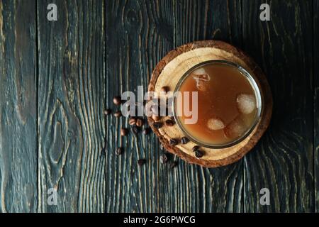 Ein Glas Eiskaffee und Bohnen auf einem Holztisch Stockfoto