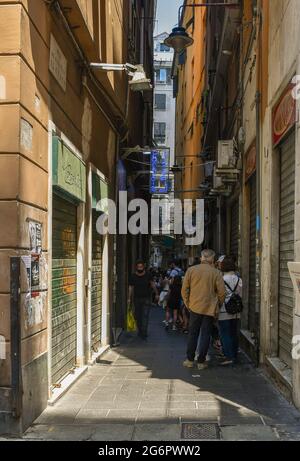 Menschen, die vor einer berühmten Focaccia (Focaccia Bäckerei) in einem typischen Carruggio (enge Gasse) im historischen Zentrum von Genua, Ligurien, Italien Schlange stehen Stockfoto