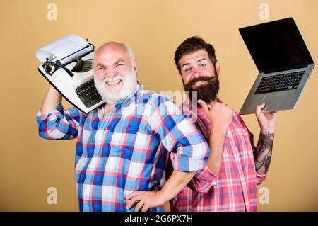 Zwei bärtige Männer. Vintage Schreibmaschine. Jugend vs Alter. Business-Ansatz. Technologie Generation Schlacht. Modernes Leben. Vater und Sohn. Technik Stockfoto
