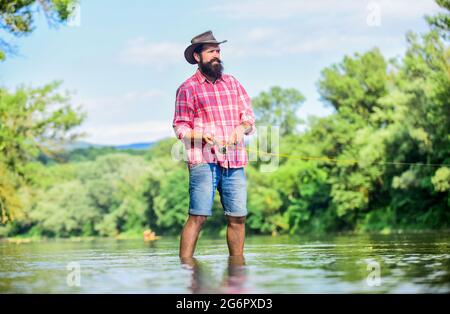 Angelausrüstung für Fischer. Hobby-Sport-Aktivität. Ruhige und friedliche Stimmung. Fischer allein stehen im Flusswasser. Eine nette Meditation. Fisch normal Stockfoto