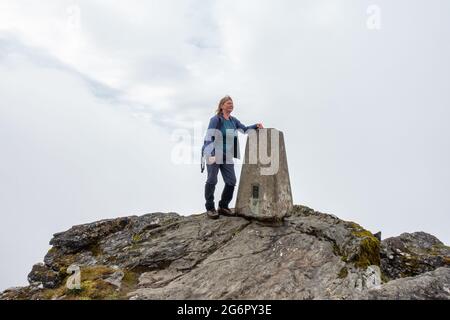 Femaile Walker am Gipfelpunkt des Munro-Berges von Ben More in der Nähe von Crianlarich, Schottland Stockfoto