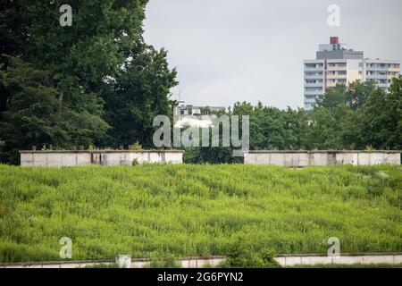 Nürnberg, Deutschland. Juli 2021. Blick auf den teilweise bewachsenen Wall auf dem ehemaligen Gelände der NSDAP-Kundgebung in Zeppelinfeld. Die mehrmillionenschwere Sanierung des ehemaligen Reichsparteitagsgeländes in Nürnberg wird lange dauern. Die Stadt will das Zeppelin-Feld und die Haupttribüne zu einem historischen Lernort entwickeln. Quelle: Daniel Karmann/dpa/Alamy Live News Stockfoto