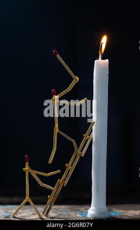 Streichhölzer in Form eines Mannes, der eine Kerze anzündet, Streichhölzer, der eine Kerze anzündet. Stockfoto