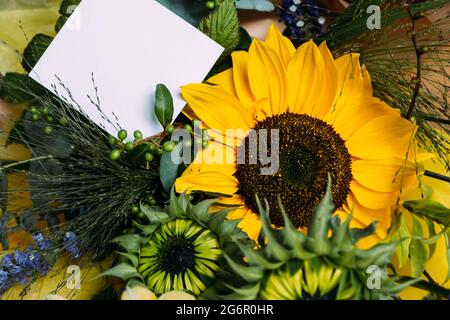 Frisch geschnittene Sonnenblumen im Blumenstrauß und Karte mit Umschlag mit Kopierfläche Stockfoto