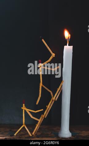 Streichhölzer in Form eines Mannes, der eine Kerze anzündet, Streichhölzer, der eine Kerze anzündet. Stockfoto