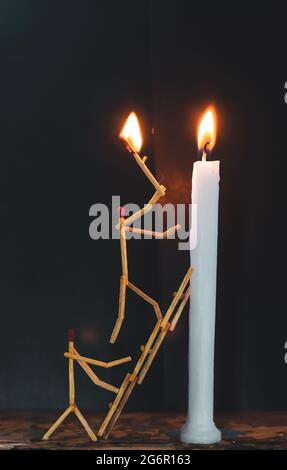 Streichhölzer in Form eines Mannes, der eine Kerze anzündet, Streichhölzer, der eine Kerze anzündet. Stockfoto