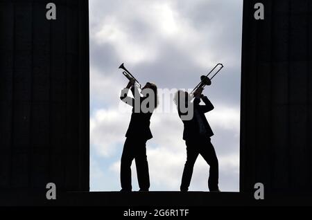 Zwei Mitglieder der Band Brass Gumbo spielen Blechblasinstrumente zwischen den Säulen des National Monument auf dem Calton Hill in Edinburgh während eines Fotoaufrufs zum Edinburgh Jazz and Blues Festival 2021. Edinburgh. Bilddatum: Donnerstag, 8. Juli 2021. Stockfoto