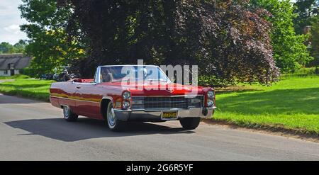 Classic Red Cadillac Eldorado Cabriolet wird durch Dorf fahren. Stockfoto