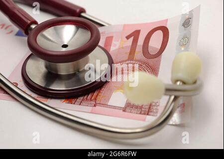 Kosten und Einnahmen im Gesundheitssektor mit Euro-Banknoten und Stethoskop Stockfoto