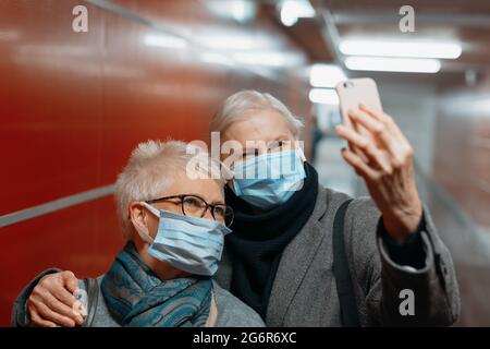 Nahaufnahme. Zwei glückliche Touristen, die Selfies in der U-Bahn machen. Stockfoto