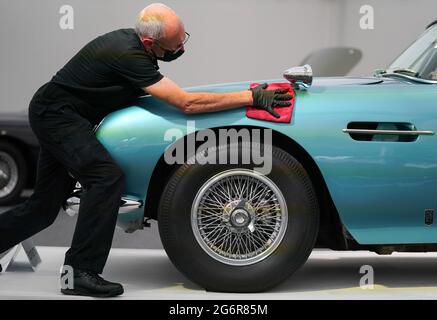 Chris Bailey, Leiter der Fahrzeugpräsentation bei Bonhams, reinigt ein 1964 Aston Martin DB5-Cabriolet, das im Bonhams Saleroom im Goodwood Estate, Chichester, West Sussex, das zuvor Prinzessin Margaret und Lord Snowdon gehörte, und dem Schauspieler Peter Sellers ausgestellt wird. Und wird geschätzt, £1.3-1.5 Millionen in der Bonhams Festival of Speed Sale am Freitag zu holen. Bilddatum: Donnerstag, 8. Juli 2021. Stockfoto