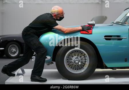Chris Bailey, Leiter der Fahrzeugpräsentation bei Bonhams, reinigt ein 1964 Aston Martin DB5-Cabriolet, das im Bonhams Saleroom im Goodwood Estate, Chichester, West Sussex, das zuvor Prinzessin Margaret und Lord Snowdon gehörte, und dem Schauspieler Peter Sellers ausgestellt wird. Und wird geschätzt, £1.3-1.5 Millionen in der Bonhams Festival of Speed Sale am Freitag zu holen. Bilddatum: Donnerstag, 8. Juli 2021. Stockfoto