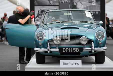 Chris Bailey, Leiter der Fahrzeugpräsentation bei Bonhams, reinigt ein 1964 Aston Martin DB5-Cabriolet, das im Bonhams Saleroom im Goodwood Estate, Chichester, West Sussex, das zuvor Prinzessin Margaret und Lord Snowdon gehörte, und dem Schauspieler Peter Sellers ausgestellt wird. Und wird geschätzt, £1.3-1.5 Millionen in der Bonhams Festival of Speed Sale am Freitag zu holen. Bilddatum: Donnerstag, 8. Juli 2021. Stockfoto