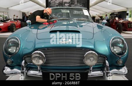 Chris Bailey, Leiter der Fahrzeugpräsentation bei Bonhams, reinigt ein 1964 Aston Martin DB5-Cabriolet, das im Bonhams Saleroom im Goodwood Estate, Chichester, West Sussex, das zuvor Prinzessin Margaret und Lord Snowdon gehörte, und dem Schauspieler Peter Sellers ausgestellt wird. Und wird geschätzt, £1.3-1.5 Millionen in der Bonhams Festival of Speed Sale am Freitag zu holen. Bilddatum: Donnerstag, 8. Juli 2021. Stockfoto