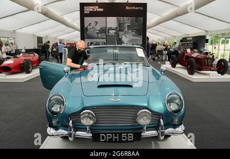 Chris Bailey, Leiter der Fahrzeugpräsentation bei Bonhams, reinigt ein 1964 Aston Martin DB5-Cabriolet, das im Bonhams Saleroom im Goodwood Estate, Chichester, West Sussex, das zuvor Prinzessin Margaret und Lord Snowdon gehörte, und dem Schauspieler Peter Sellers ausgestellt wird. Und wird geschätzt, £1.3-1.5 Millionen in der Bonhams Festival of Speed Sale am Freitag zu holen. Bilddatum: Donnerstag, 8. Juli 2021. Stockfoto