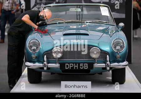Chris Bailey, Leiter der Fahrzeugpräsentation bei Bonhams, reinigt ein 1964 Aston Martin DB5-Cabriolet, das im Bonhams Saleroom im Goodwood Estate, Chichester, West Sussex, das zuvor Prinzessin Margaret und Lord Snowdon gehörte, und dem Schauspieler Peter Sellers ausgestellt wird. Und wird geschätzt, £1.3-1.5 Millionen in der Bonhams Festival of Speed Sale am Freitag zu holen. Bilddatum: Donnerstag, 8. Juli 2021. Stockfoto