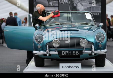 Chris Bailey, Leiter der Fahrzeugpräsentation bei Bonhams, reinigt ein 1964 Aston Martin DB5-Cabriolet, das im Bonhams Saleroom im Goodwood Estate, Chichester, West Sussex, das zuvor Prinzessin Margaret und Lord Snowdon gehörte, und dem Schauspieler Peter Sellers ausgestellt wird. Und wird geschätzt, £1.3-1.5 Millionen in der Bonhams Festival of Speed Sale am Freitag zu holen. Bilddatum: Donnerstag, 8. Juli 2021. Stockfoto