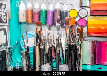 Nahaufnahme von Farben, Schablonen, Bürsten und anderen Geräten, die für die Gesichtsmalerei verwendet werden. Stockfoto