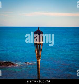 Eine erloschene Fackel vor dem Meer vor der Küste von Mijas Stockfoto