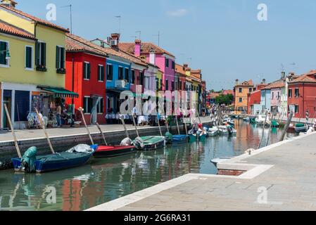 Ein belebtes Restaurant neben einem Kanal im kleinen Fischerdorf und kleinen Hafen von Burano, auf einer Insel in der Lagune von Venedig, etwa 7 km von Venedig entfernt Stockfoto