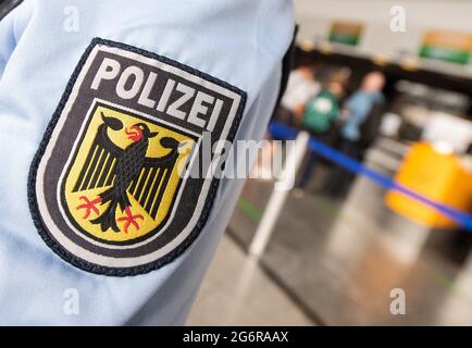 08. Juli 2021, Hessen, Frankfurt/Main: Eine Patrouille der Bundespolizei geht durch das Terminal 1 des Frankfurter Flughafens. Das Wappen der Bundespolizei ist auf einer Uniform zu sehen. Mit den sich ständig ändernden Definitionen von Virenvariantenbereichen hat sich auch die tägliche Arbeit von Beamten, die ein- und ausgehende Passagiere kontrollieren, geändert. Foto: Boris Roessler/dpa Stockfoto