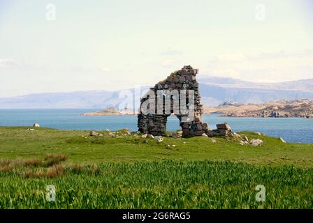 Ruinen eines Tores in einer alten Steinmauer, Iona, Schottland mit der Insel Mull dahinter Stockfoto