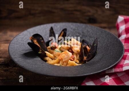 Ein Fisch und Meeresfrüchte busiate Pasta mit Muscheln und Garnelen auf einer schwarzen Palte Stockfoto