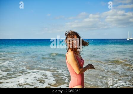 Glückliche Frau mit Spaß am Strand während der Sommerferien - Fokus auf weiblichen Rücken Stockfoto