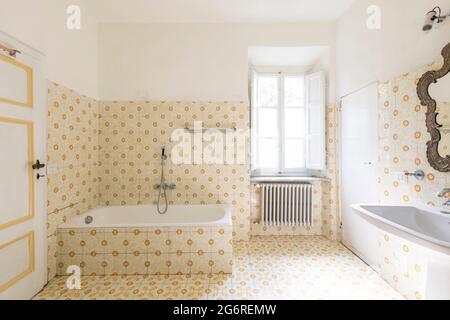 Interieur eines alten Badezimmers mit Fenster und Badewanne. Stockfoto