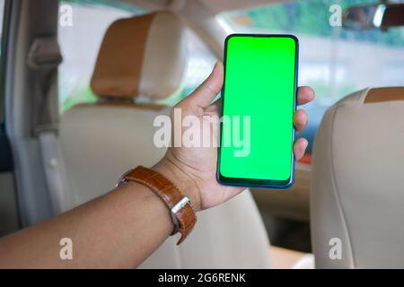 Mann Hand hält Smartphone in einem Auto Stockfoto