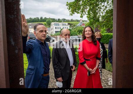 Schengen, Luxemburg. Juli 2021. Der deutsche Außenminister Heiko Maas (l-r, SPD) lehnt sich in Anwesenheit von Jean-Yves Le Drian, Außenminister Frankreichs und Schauspielerin Christine Neubauer, gegen das Schengen-Denkmal. Quelle: Harald Tittel/dpa/Alamy Live News Stockfoto