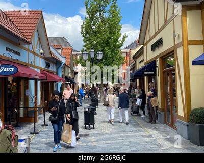 Roermond (Designer Outlet), Niederlande - 1. Juli. 2021: Blick auf die Straße mit Geschäften und Leuten, die im Sommer draußen einkaufen Stockfoto