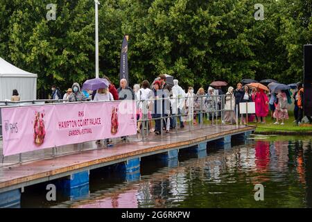 East Molesey, Surrey, Großbritannien. Juli 2021. Es war ein sehr geschäftiger Tag heute am 4. Tag des RHS Hampton Court Palace Garden Festivals. Im echten britischen Stil schien die Sonne am Morgen, aber am Nachmittag folgten heftige Duschen, da Sonnenschirme und Ponchos die Accessoires waren, die man unbedingt haben sollte. Quelle: Maureen McLean/Alamy Live News Stockfoto