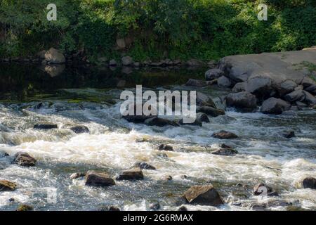 Wasser fließt über Felsen in einem Fluss in der französischen Landschaft Stockfoto