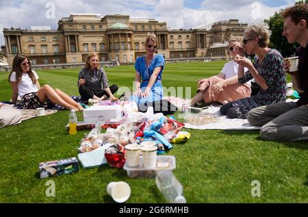 Besucher genießen ein Picknick auf dem Rasen während einer Vorschau auf den Garten im Buckingham Palace, der offiziellen Residenz von Königin Elizabeth II. In London, der am Freitag für die Öffentlichkeit geöffnet ist. Die Besucher können im Garten picknicken und den Freiraum zum ersten Mal erkunden. Bilddatum: Donnerstag, 8. Juli 2021. Stockfoto