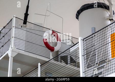 Ein rot-weißer Rettungsring auf dem Oberdeck eines alten Schiffes Stockfoto