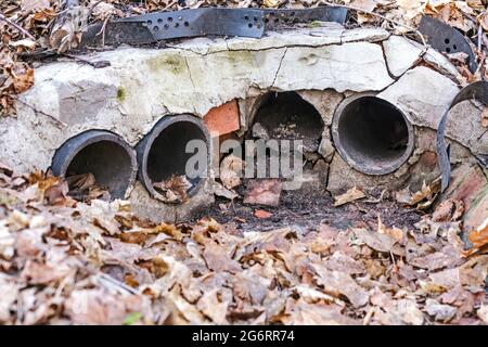 Echte alte Abflussrohre im Boden an wolkigen Frühlingstag Stockfoto