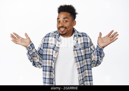 Tut mir leid. Umständlicher afroamerikanischer Typ, junger Mann, der mit den Schultern zuckt und die Hände hochhebt, lächelt albern, entschuldigt sich, weiß nicht, wie es geht, steht Stockfoto