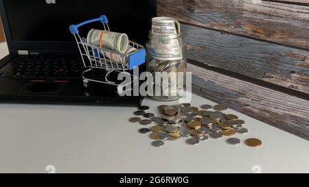 Shopping Sale Rabattkonzept. Selektiver Fokus auf Warenkorb, Falschgeld und Münzen. Stockfoto