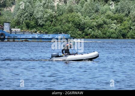 Angeln auf dem Fluss. Fischer fangen Fische von einem Boot auf dem Fluss. Stockfoto