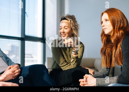 Close-up Face junge Frauen hören den Kollegen beim Brainstorming von Start-up-Projekten in einem modernen Büroraum aufmerksam zu Stockfoto