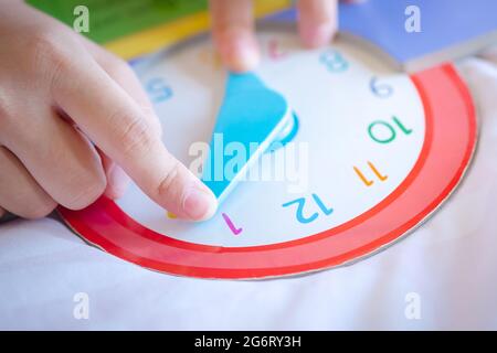 Kind spielen sagen Zeit Spiel, kleine Kinder zu lernen, wie man eine analoge Uhr zu lesen. Stockfoto