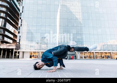 Coole Breakdancer, die auf der Straße üben und Spaß haben. Er tanzt und schaut in die Kamera. Stockfoto